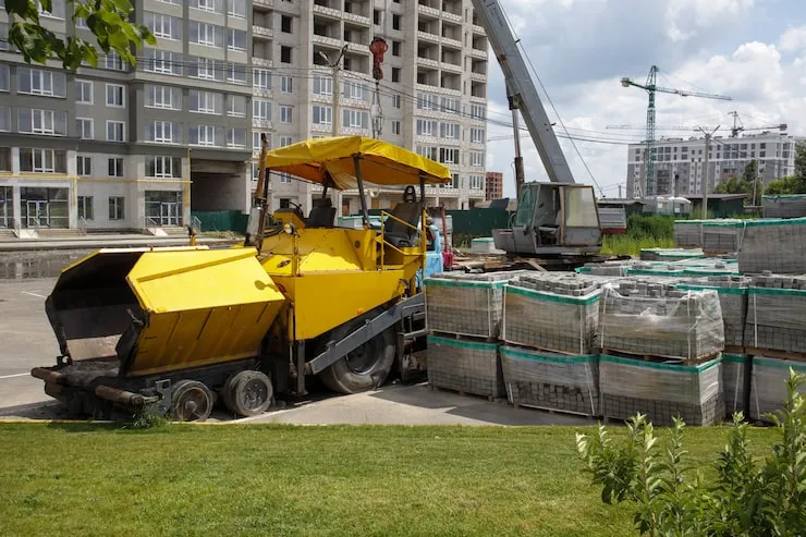asphalt-paver-is-parked-construction-site-road-construction-machinery-stands-by-road-warehouse-construction-heavy-roads-repair-city-streets